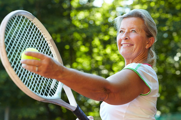 Getting ready to serve - Tennis technique. Senior woman preparin